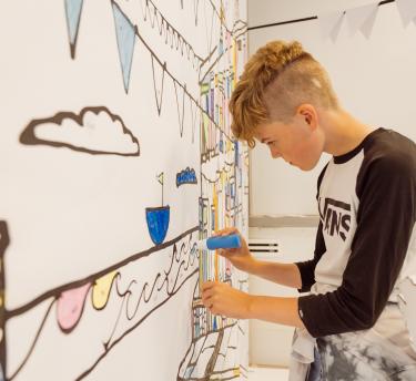 Boy colouring in a giant 3D paint-by-numbers